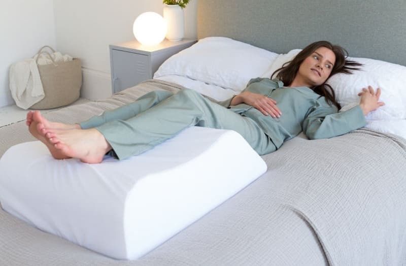 Nằm ngửa và kê gối dưới chân